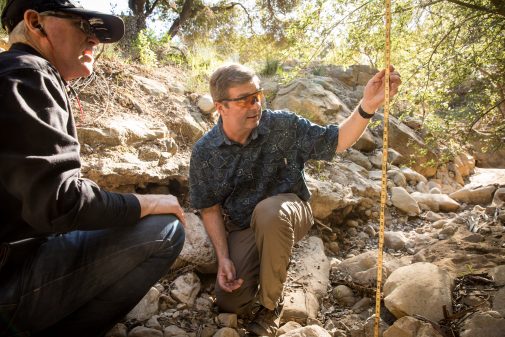 Troy Harris and Brett Gracely take measurements of the Chelham Creek channel through campus