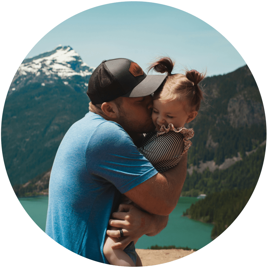 man kissing daughter in arms